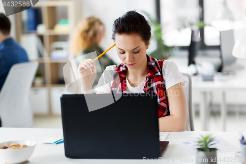 Image of creative woman with laptop computer at office