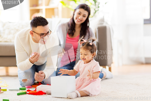 Image of baby girl with birthday gift and parents at home 