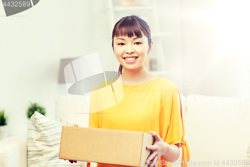 Image of happy asian young woman with parcel box at home