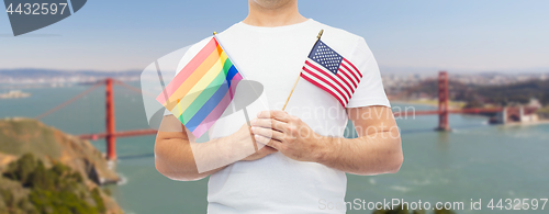 Image of man with gay pride rainbow flag and american