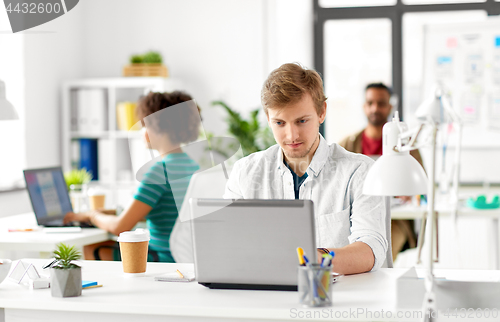 Image of creative male office worker with laptop