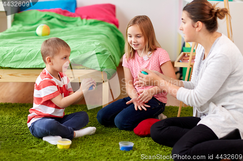 Image of kids and mother with modelling clay or slimes