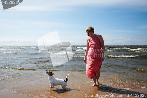 Image of Woman and dog standing in sea