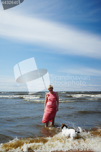 Image of Woman and dog standing in sea