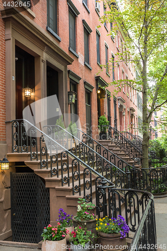 Image of Row of old brownstone buildings along an empty sidewalk block in the Greenwich Village neighborhood of Manhattan, New York City NYC