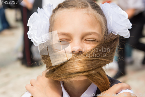 Image of The schoolgirl on a holiday on September 1 covered her face with her long hair