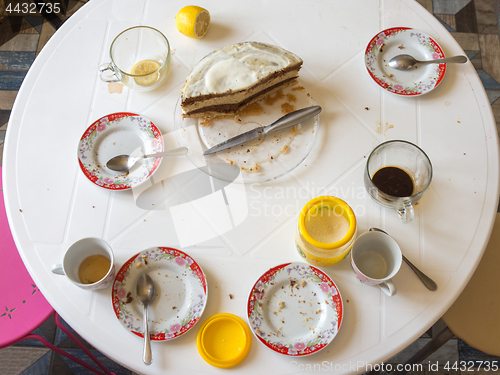 Image of Dirty dishes and half of the homemade cake on the table