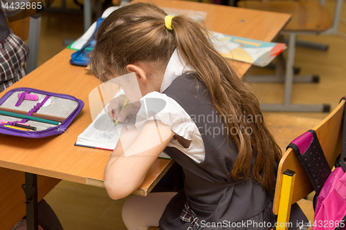 Image of Schoolgirl with a wrong posture in class at school