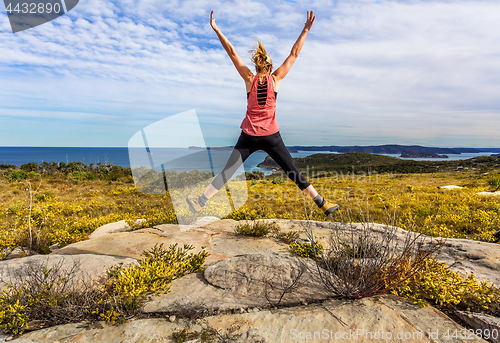 Image of Spring has sprung Woman jumping among wildflowers