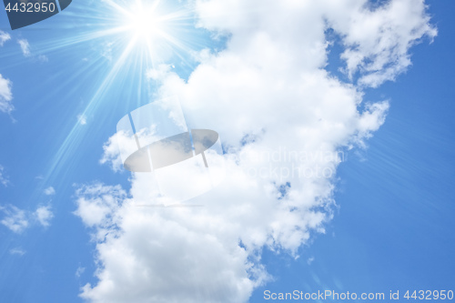 Image of blue sky with bright sun and white clouds