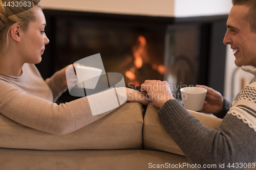 Image of Young couple  in front of fireplace