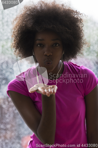 Image of portrait of young afro american woman in gym while listening mus