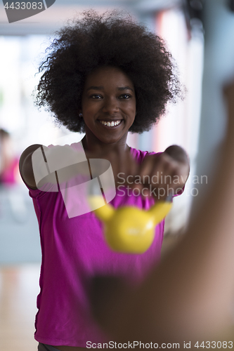Image of woman working out in a crossfit gym with dumbbells