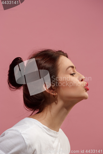 Image of Portrait of attractive cute girl with bright makeup with kiss isolated over pink background