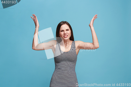 Image of Portrait of an angry woman looking at camera isolated on a blue background