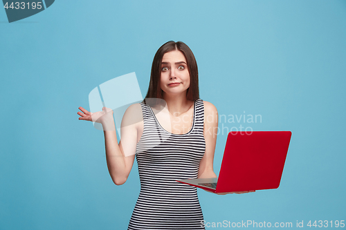 Image of Businesswoman with laptop on blue studio