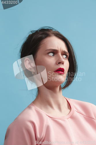 Image of Let me think. Doubtful pensive woman with thoughtful expression making choice against blue background