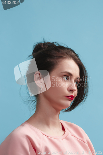 Image of Let me think. Doubtful pensive woman with thoughtful expression making choice against blue background