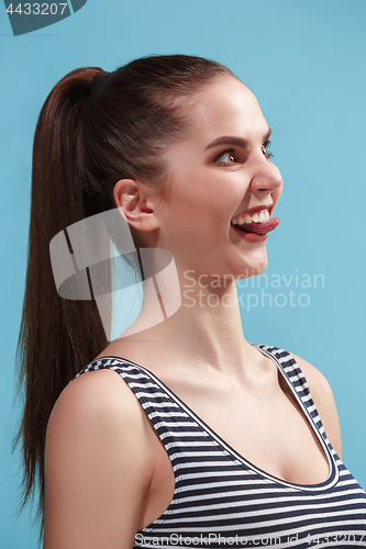 Image of The young woman is looking crazy on the blue background.