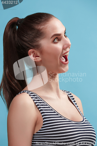 Image of The young woman is looking crazy on the blue background.