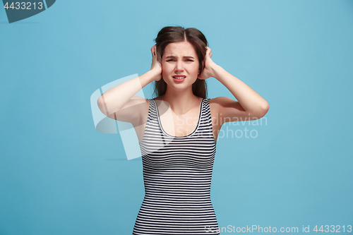 Image of Woman having headache. Isolated over blue background.