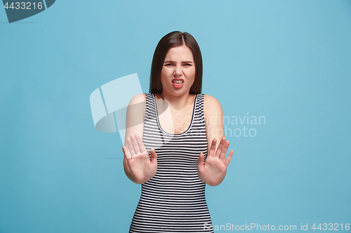 Image of Let me think. Doubtful pensive woman with thoughtful expression making choice against blue background