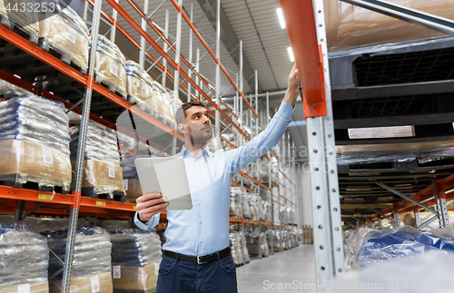 Image of businessman with tablet pc at warehouse