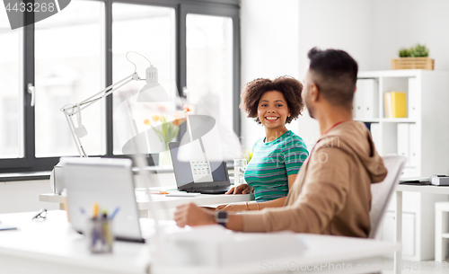 Image of happy creative workers with laptops at office