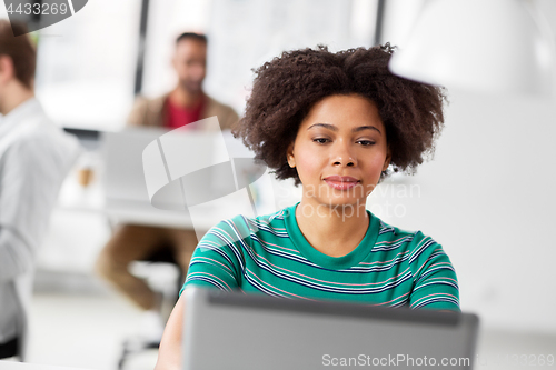 Image of african woman with laptop computer at office
