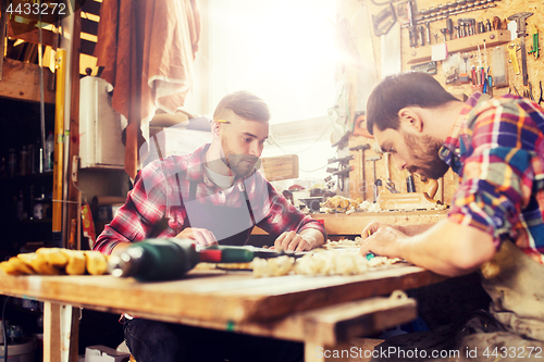 Image of carpenters with ruler and blueprint at workshop