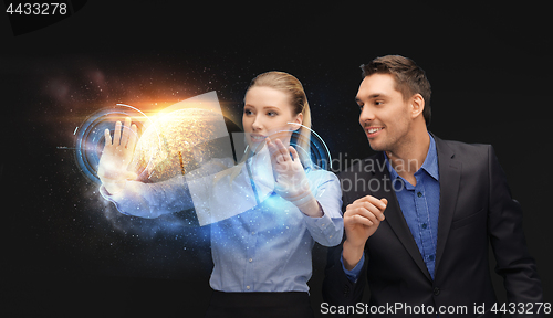 Image of businessman and businesswoman with planet hologram
