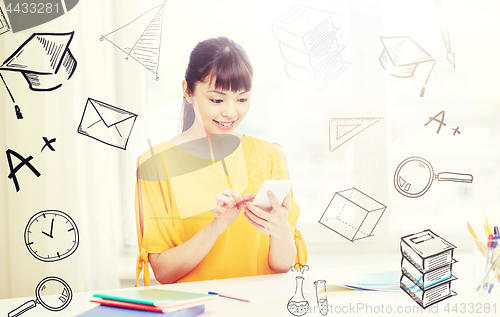 Image of happy young woman student with smartphone at home