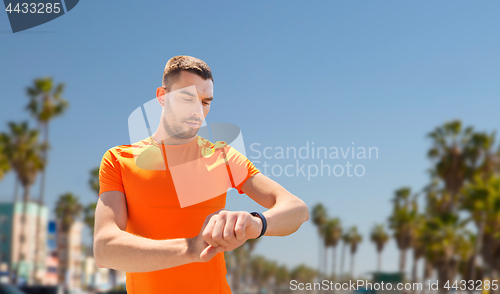 Image of man with fitness tracker training outdoors