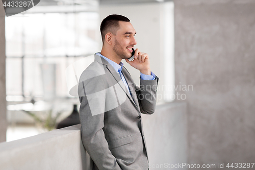Image of businessman calling on smartphone at office