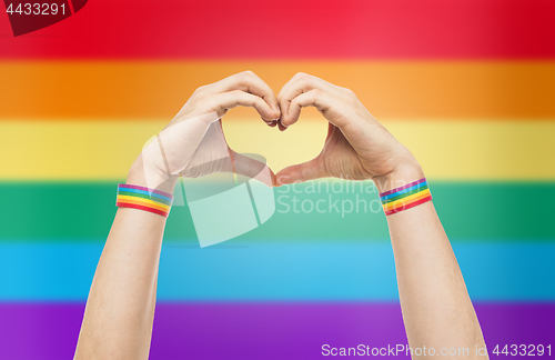 Image of male hands with gay pride wristbands showing heart