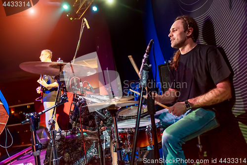 Image of Drummer playing on drum set on stage.