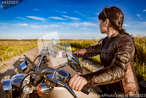 Image of Biker girl sitting on motorcycle