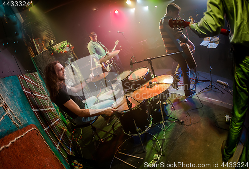 Image of Drummer playing on drum set on stage.