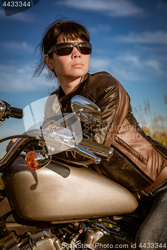 Image of Biker girl sitting on motorcycle