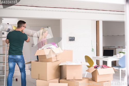 Image of couple carrying a carpet moving in to new home