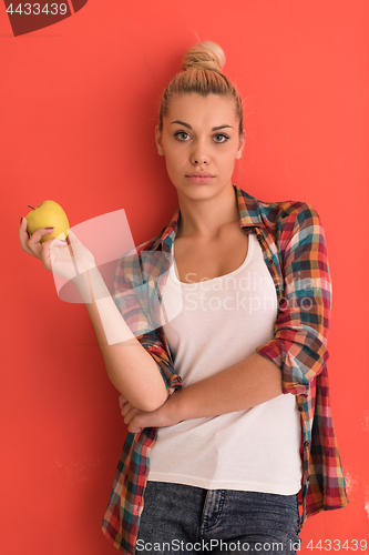 Image of woman over color background plays with apple