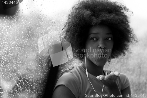 Image of portrait of young afro american woman in gym while listening mus