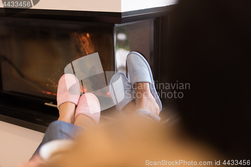 Image of Young multiethnic couple  in front of fireplace