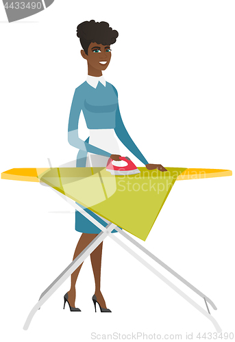 Image of African maid ironing clothes on ironing board.