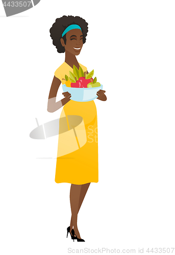 Image of Young pregnant woman with bowl of fruits.