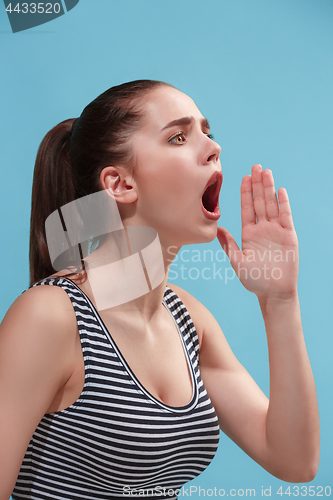 Image of The young woman is calling on the blue background.