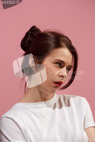 Image of The serious business woman standing against pink background.