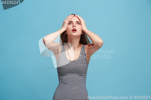 Image of Woman having headache. Isolated over blue background.