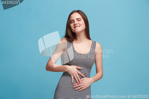 Image of The happy business woman standing and smiling against blue background.