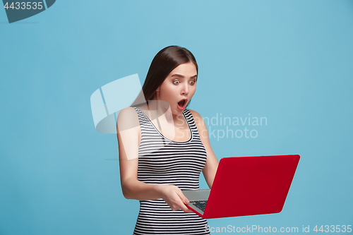 Image of Businesswoman with laptop on blue studio